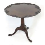 A 19thC mahogany tripod table with a carved one piece top above a fluted tapering stem and three
