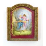 A Continental Limoges style plaque with hand painted decoration depicting a couple in a landscape