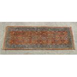 Carpet / Rug : A runner, the salmon ground with floral and foliate detail and decorative blue and