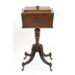 A Regency mahogany teapoy with a carved handle and sarcophagus shaped top, egg and dart mouldings