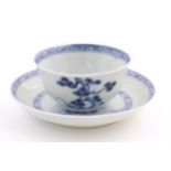 A Chinese Nanking Cargo blue and white tea bowl and saucer, decorated with pine trees and banded