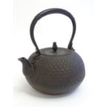 An Oriental cast tetsubin style teapot / kettle with relief decoration. Approx. 9 1/2" high Please