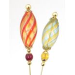Two gilt metal hatpins surmounted by Venetian glass decoration. Approx 4 1/2" long Please Note -