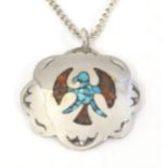 A silver pendant with enamel detail depicting a stylised bird. Pendant approx. 1 1/4" diameter