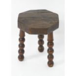 A 19thC three legged milking stool with bobbin turned legs. 14" high. Please Note - we do not make