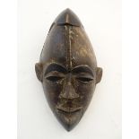Ethnographic / Native / Tribal: An African carved hardwood mask with relief detail to forehead and