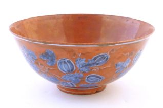 A Chinese bowl with a red ground decorated with vine leaves and gourds. Character marks under.