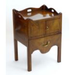 A Georgian mahogany tray top commode, with pierced handles to the top above two doors and pull out