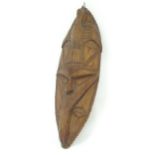 Ethnographic / Native / Tribal: A carved hardwood mask with bird detail, cowrie shell eyes and