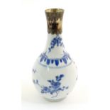 An Oriental blue and white bottle vase with silver plate collar, the body decorated with prunus