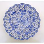 An Oriental blue and white plate with scalloped edge decorated with a stylised exotic pheasant