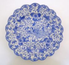An Oriental blue and white plate with scalloped edge decorated with a stylised exotic pheasant