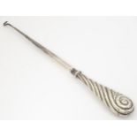 A silver handled button hook. Approx. 10 3/4" long Please Note - we do not make reference to the