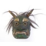 A Japanese carved Midori Oni mask with hair and traces of polychrome decoration. Approx. 12"