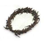 A 19thC bronze mirror in the form of a wreath with a bow. 18 1/2" wide x 23" high. Please Note -