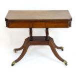 A 19thC mahogany card table with canted edges and carved rosettes above four turned supports and