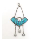 An Arts and Crafts white metal pendant with turquoise enamel decoration and mother of pearl and seed