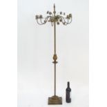 An early to mid 20thC patinated metal floor standing candelabra, the six cups formed as flower