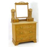 An early 20thC walnut dressing table with maple veneered drawers. Having shaped pierced supports and