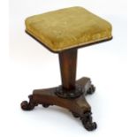 A William IV rosewood piano stool with a square top above a canted column and triform base with
