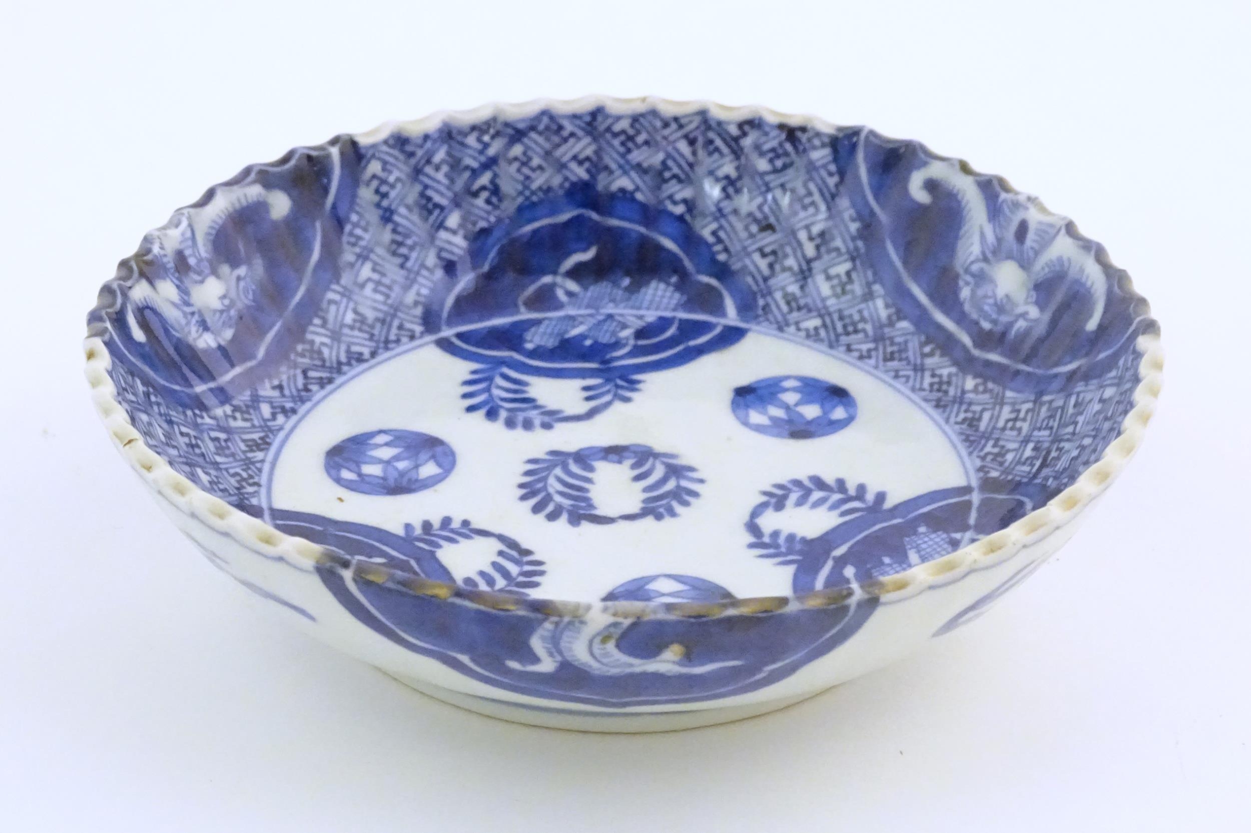 An Oriental blue and white dish with fluted rim, decorated with auspicious scroll symbols, wreaths