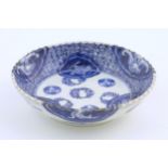 An Oriental blue and white dish with fluted rim, decorated with auspicious scroll symbols, wreaths
