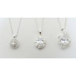 Three silver / white metal necklaces set with various pendants. Largest pendant approx. 1 1/4"