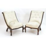 A pair of mid 20thC nursing chairs with scrolled backs, show wood frames and deep buttoned