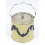 A Wedgwood biscuit barrel with a silver plate lid and swing handle, the body with relief fruiting