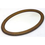 A 20thc oak framed oval mirror. 33" wide x 20" high. Please Note - we do not make reference to the