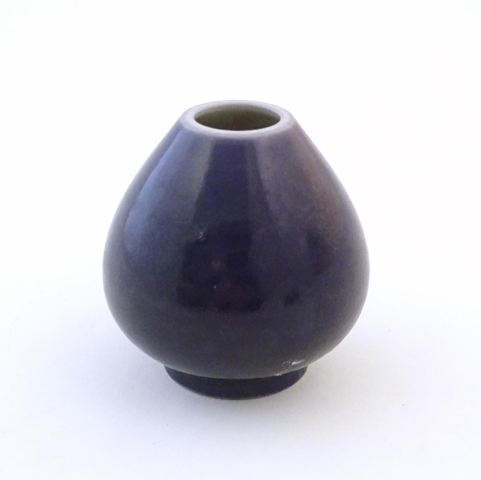 A small Chinese pot of teardrop form with an indigo glaze. Character marks under. Approx. 2" high