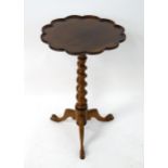 A rosewood tripod table with a scallop moulded top above a barley twist column and three chamfered