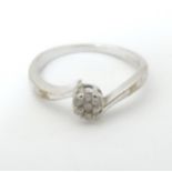 A 9ct white gold ring with diamonds in a daisy setting. Ring size approx. M Please Note - we do