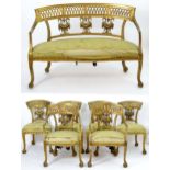 An early 20thC giltwood salon suite comprising four side chairs, two open armchairs and a sofa.