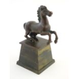 An early 20thC cast model of a rearing horse, on a tapered plinth base. Approx. 5 3/4" overall
