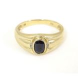 A 9ct gold ring set with central dark stone flanked by diamonds. Ring size approx. U 1/2 Please Note