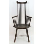 A late 19thC comb back Windsor chair in the manner of Liberty & Co. The chair having a dished