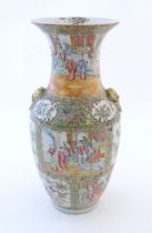 A Chinese famile rose vase with a flared rim and twin ring mask handles in relief, decorated with
