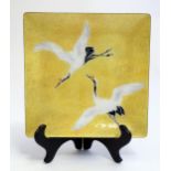 A 20thC Japanese square plate with enamel decoration depicting to cranes in flight. Tutanka label