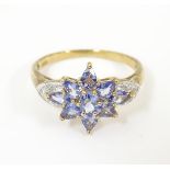 A 9ct gold ring set with tanzanite coloured stone flanked by diamonds. Ring size approx. P Please