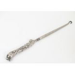 A Victorian button hook with white metal handle with acanthus a lions head detail. Approx. 9" long