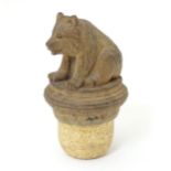 A 20thC bottle stopper, decorated with carved hardwood black forest style sitting bear,