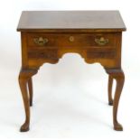 An early 20thC walnut lowboy with a burr walnut rectangular top above one long drawer and two