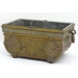A 19thC cast brass container / box with twin ring handles, hammered detail and flaming urn and