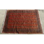 Carpet / Rug : A red ground rug with banded medallion motifs. Approx. 115" x 77" Please Note - we do