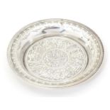 An Egyptian silver dish with engraved decoration. Approx. 2 1/4" diameter Please Note - we do not