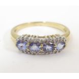 A 9ct gold ring set with 4 tanzanite coloured stones bordered by diamonds. Ring size approx. O 1/2