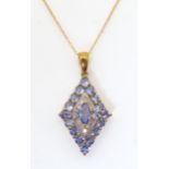 A 9ct gold necklace, the pendant set with a tanzanite coloured stones and chip set diamonds on a