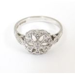 A 9ct white gold ring set with central diamond detail flanked by a further diamond to each shoulder.