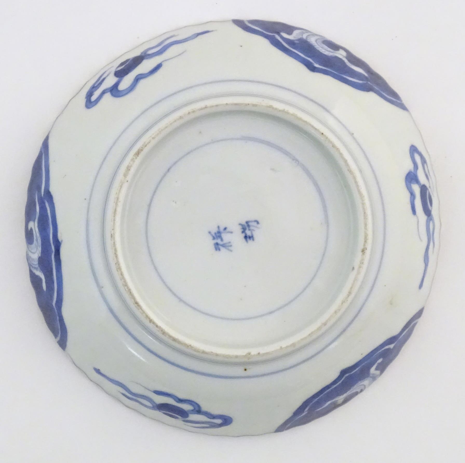 An Oriental blue and white dish with fluted rim, decorated with auspicious scroll symbols, wreaths - Image 6 of 6